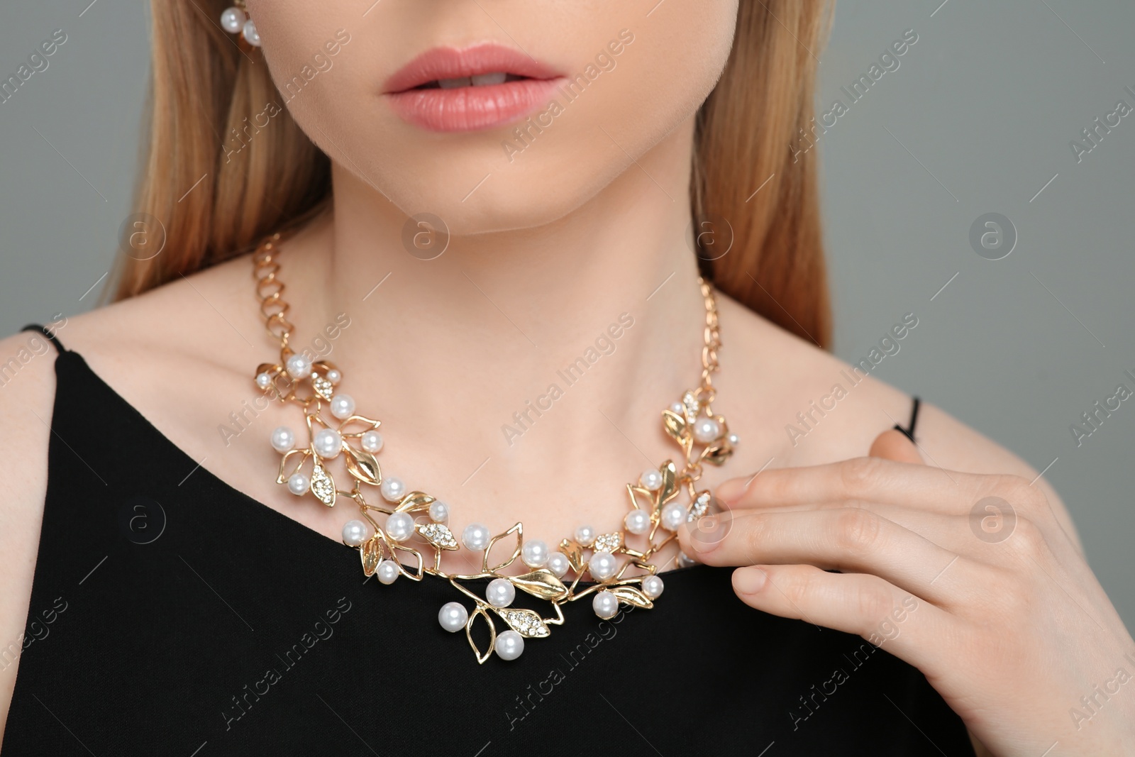 Photo of Woman with elegant necklace on gray background, closeup