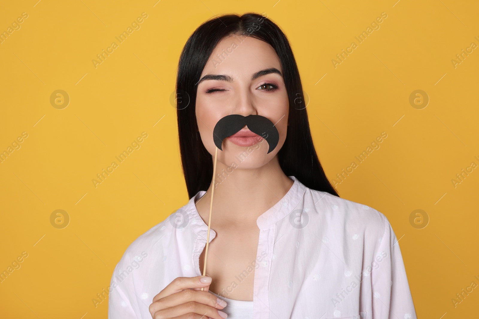 Photo of Funny woman with fake mustache on yellow background