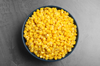 Photo of Delicious canned corn in bowl on grey table, top view