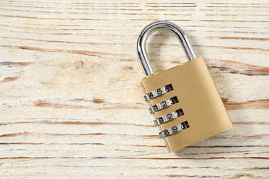 One steel combination padlock on light wooden table, top view. Space for text