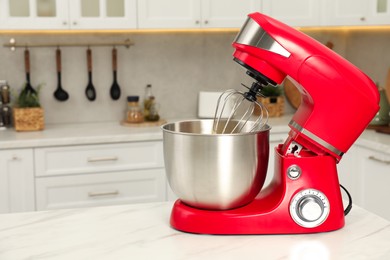 Photo of Modern red stand mixer on white marble table in kitchen, space for text