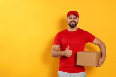 Photo of Courier holding cardboard box on yellow background, space for text