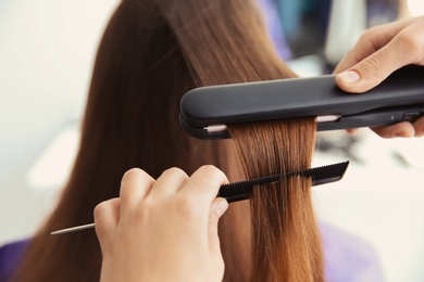 Photo of Professional hairdresser working with client in salon