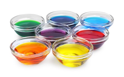 Glass bowls with different food coloring on white background