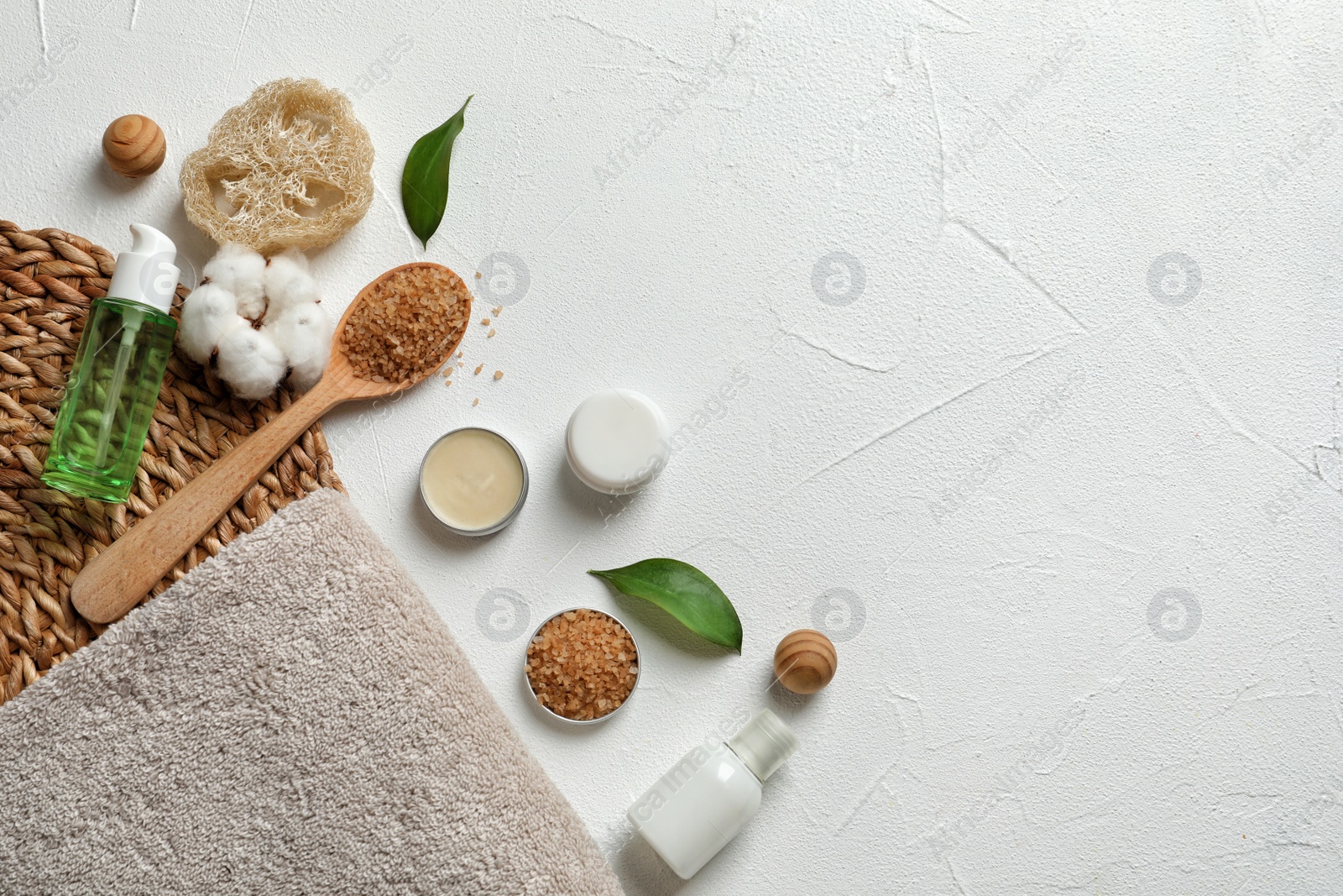 Photo of Flat lay composition with spa cosmetics and towel on white background