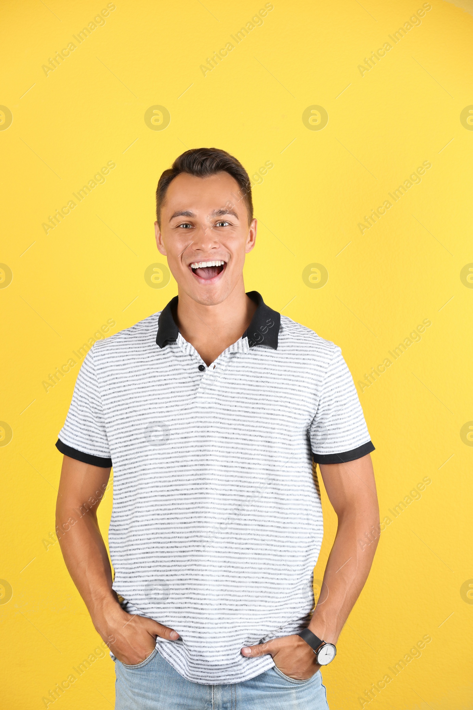 Photo of Portrait of handsome young man laughing on color background