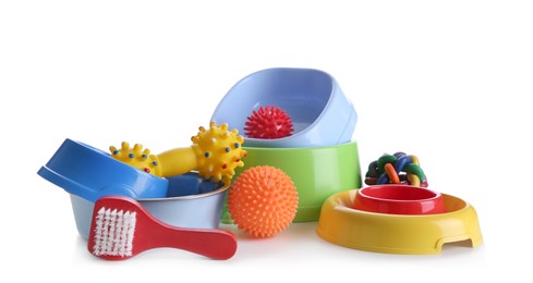 Feeding bowls, brush and dog toys on white background