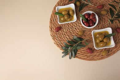 Photo of Olives and tree twigs on beige table, top view. Space for text