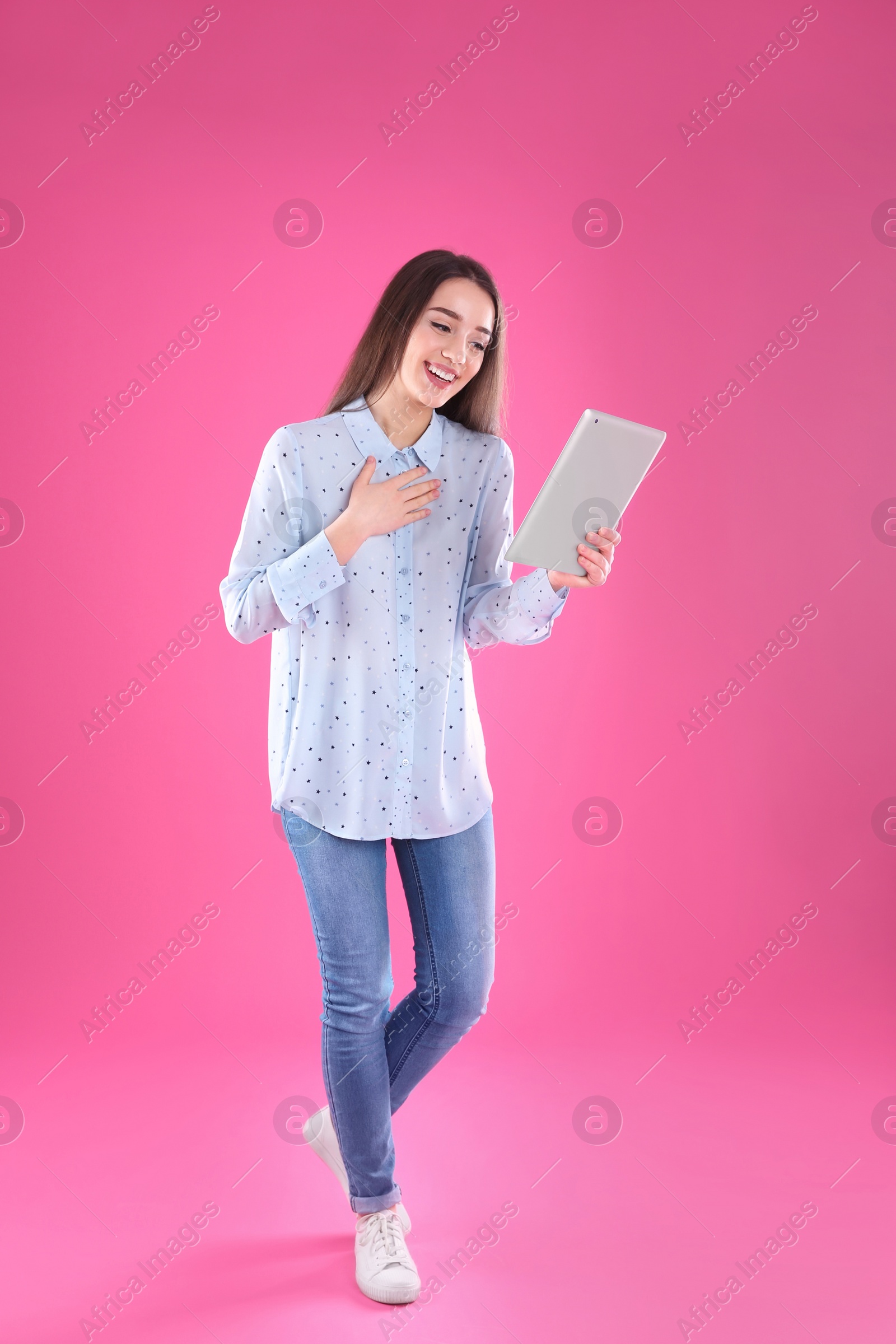 Photo of Woman using tablet for video chat on color background