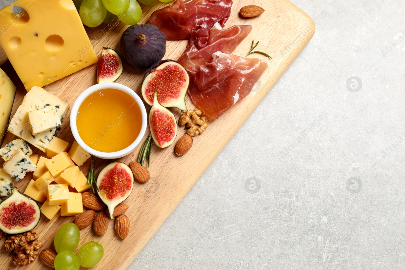 Photo of Set of different snacks with ripe figs served on light table, top view. Space for text