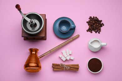 Flat lay composition with vintage manual coffee grinder and turkish pot on pink background