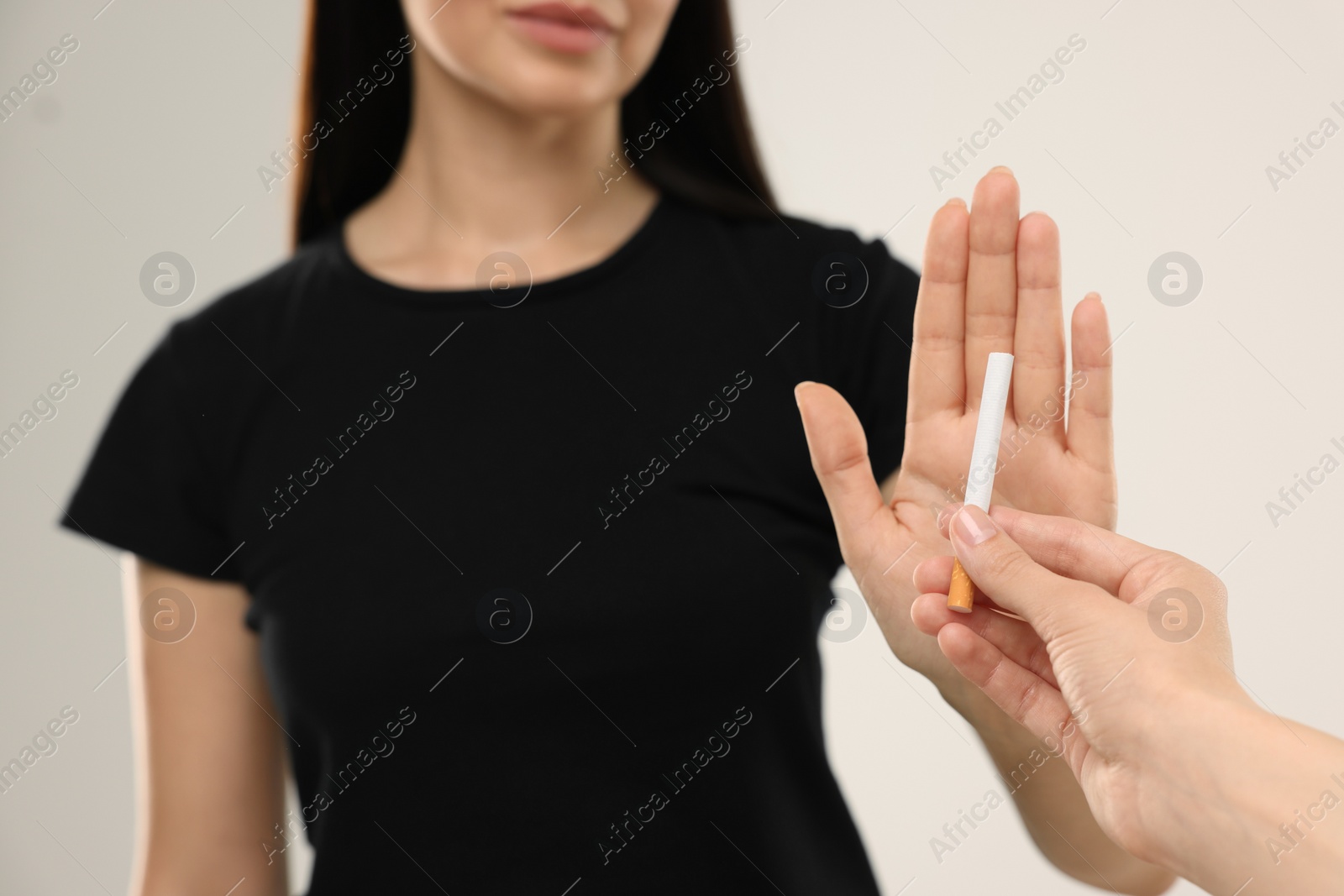 Photo of Stop smoking concept. Woman refusing cigarette on beige background, closeup