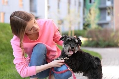 Photo of Young woman with Miniature Schnauzer dog outdoors