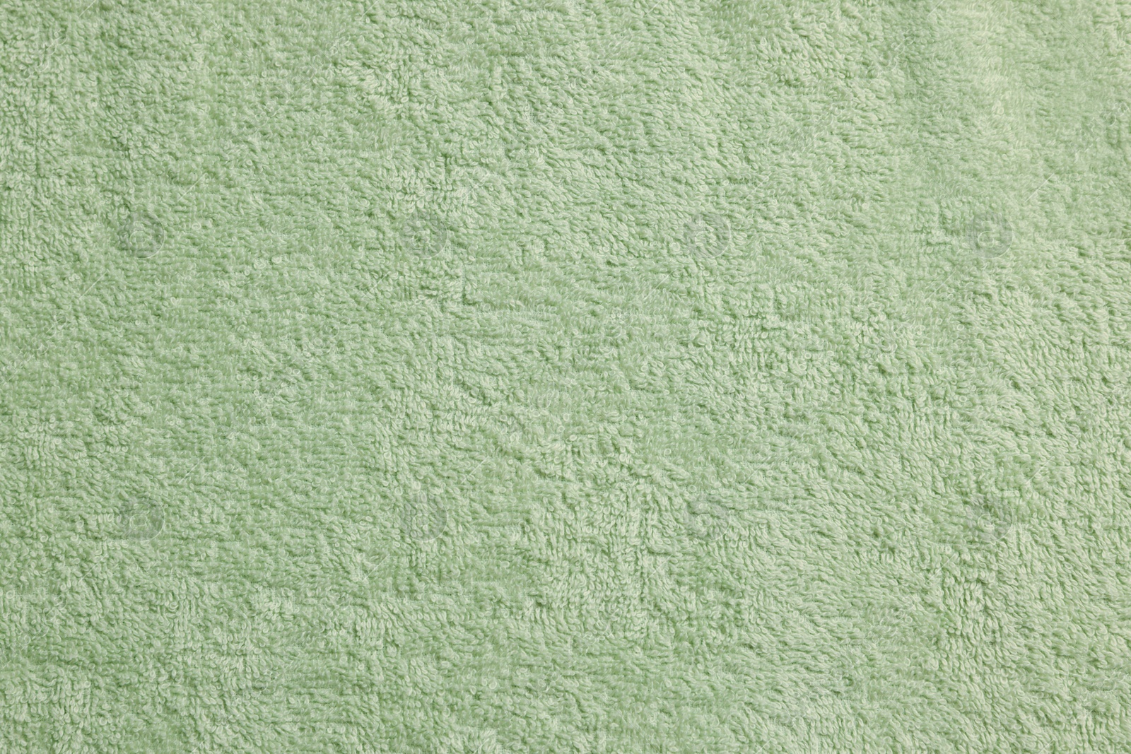 Photo of Soft pale olive towel as background, top view