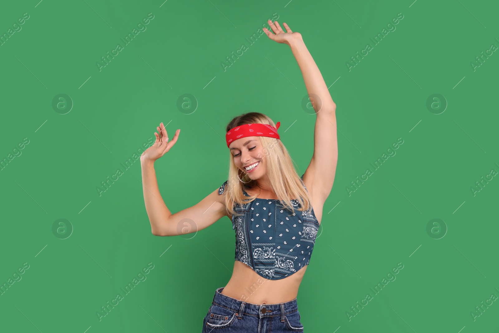 Photo of Portrait of happy hippie woman dancing on green background