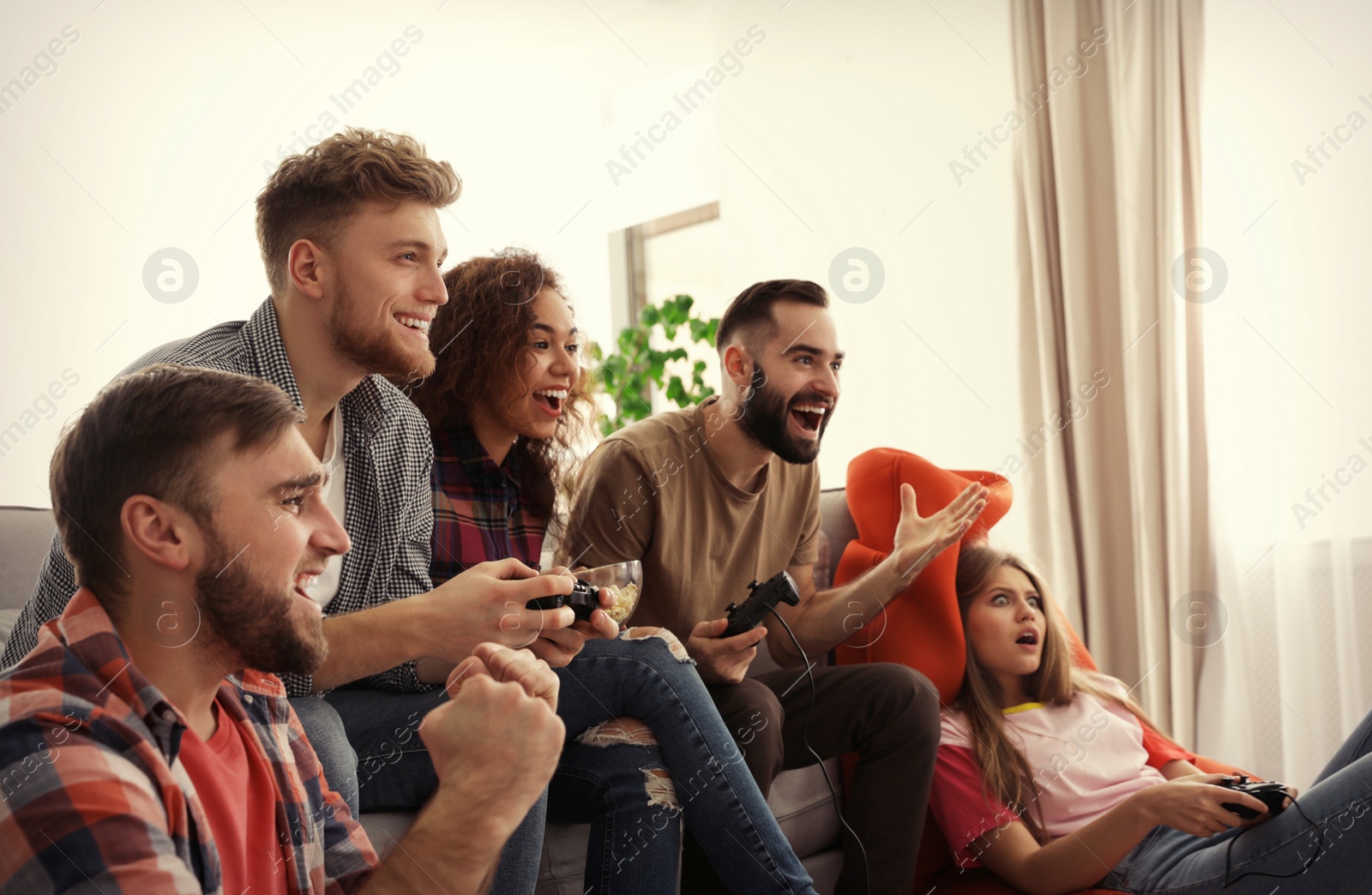 Photo of Emotional friends playing video games at home