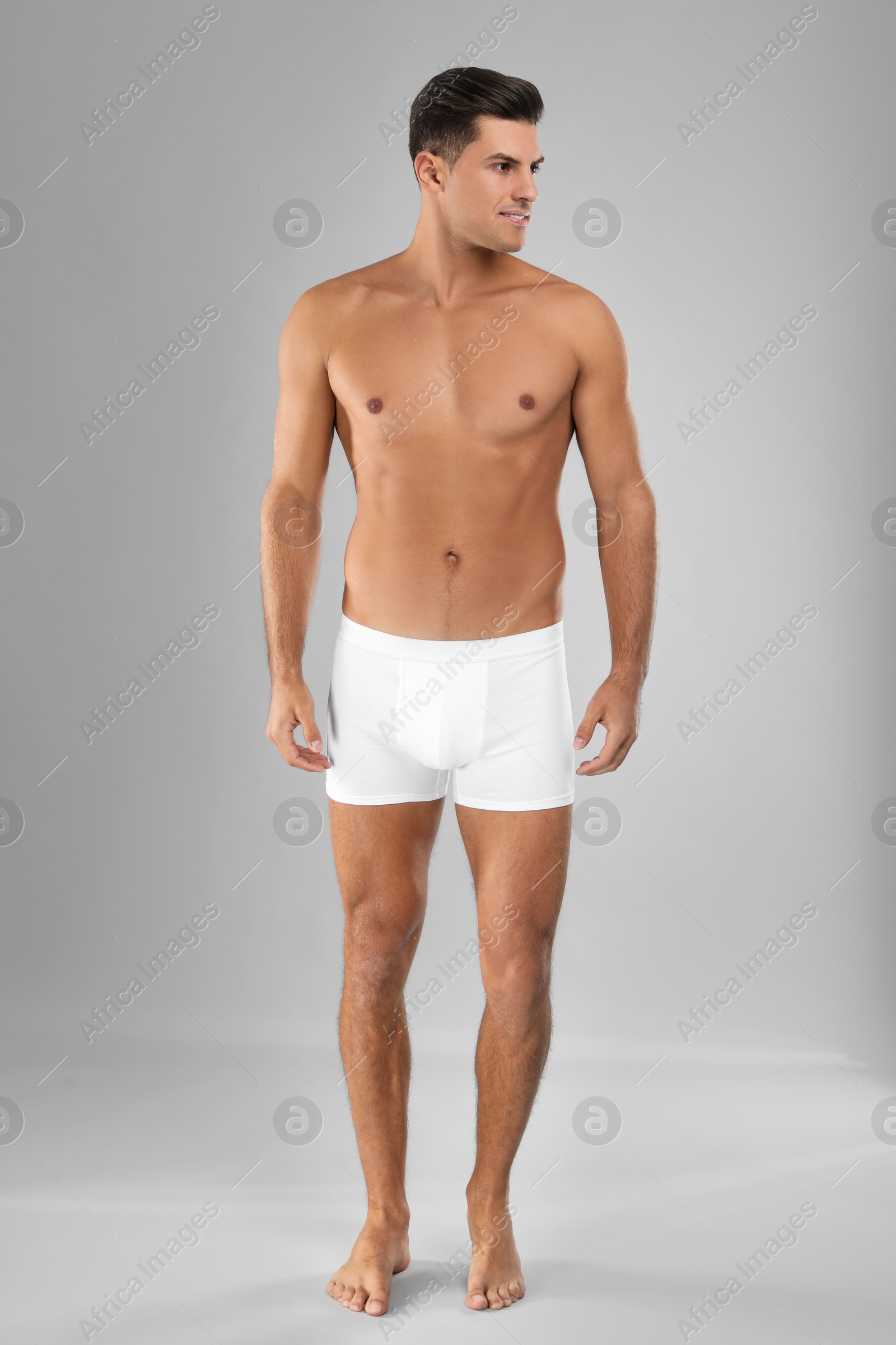 Photo of Handsome man in white underwear on light grey background