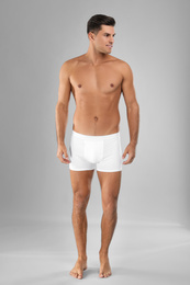 Photo of Handsome man in white underwear on light grey background