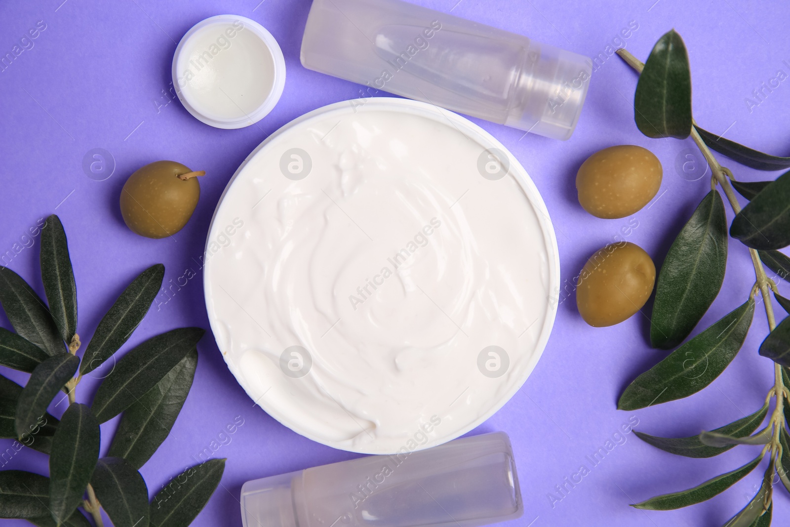 Photo of Different cosmetic products and olives on violet background, flat lay