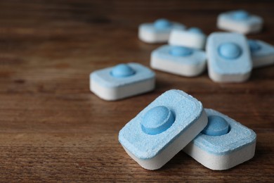 Water softener tablets on wooden table, closeup. Space for text