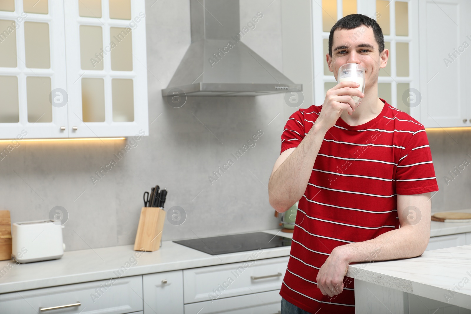 Photo of Milk mustache left after dairy product. Man drinking milk in kitchen