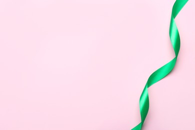 Photo of Beautiful ribbon on pink background, top view. Space for text