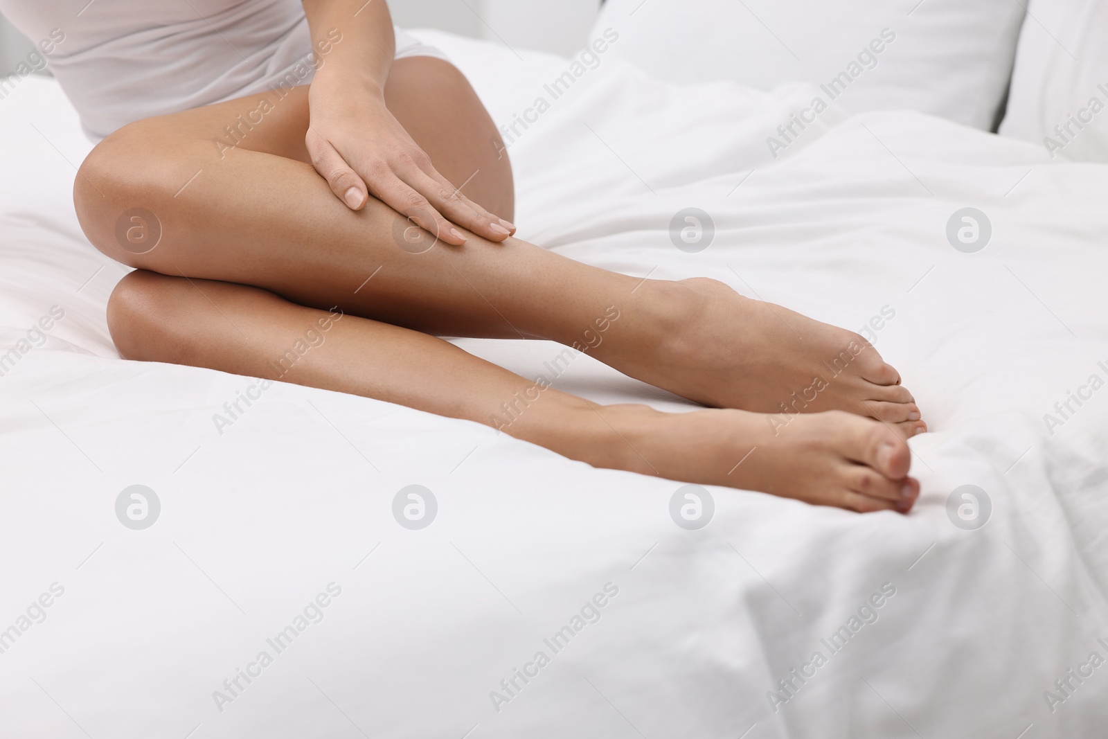 Photo of Woman with beautiful legs in bed, closeup