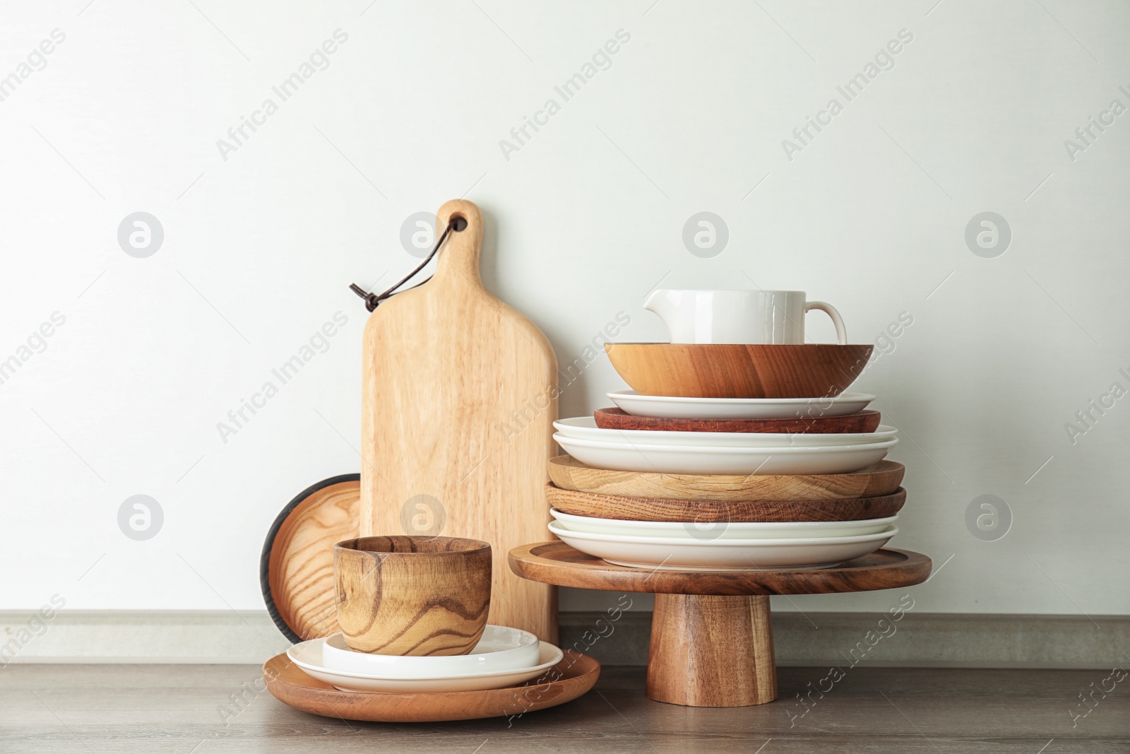 Photo of Set of dishware on table against light background. Interior element