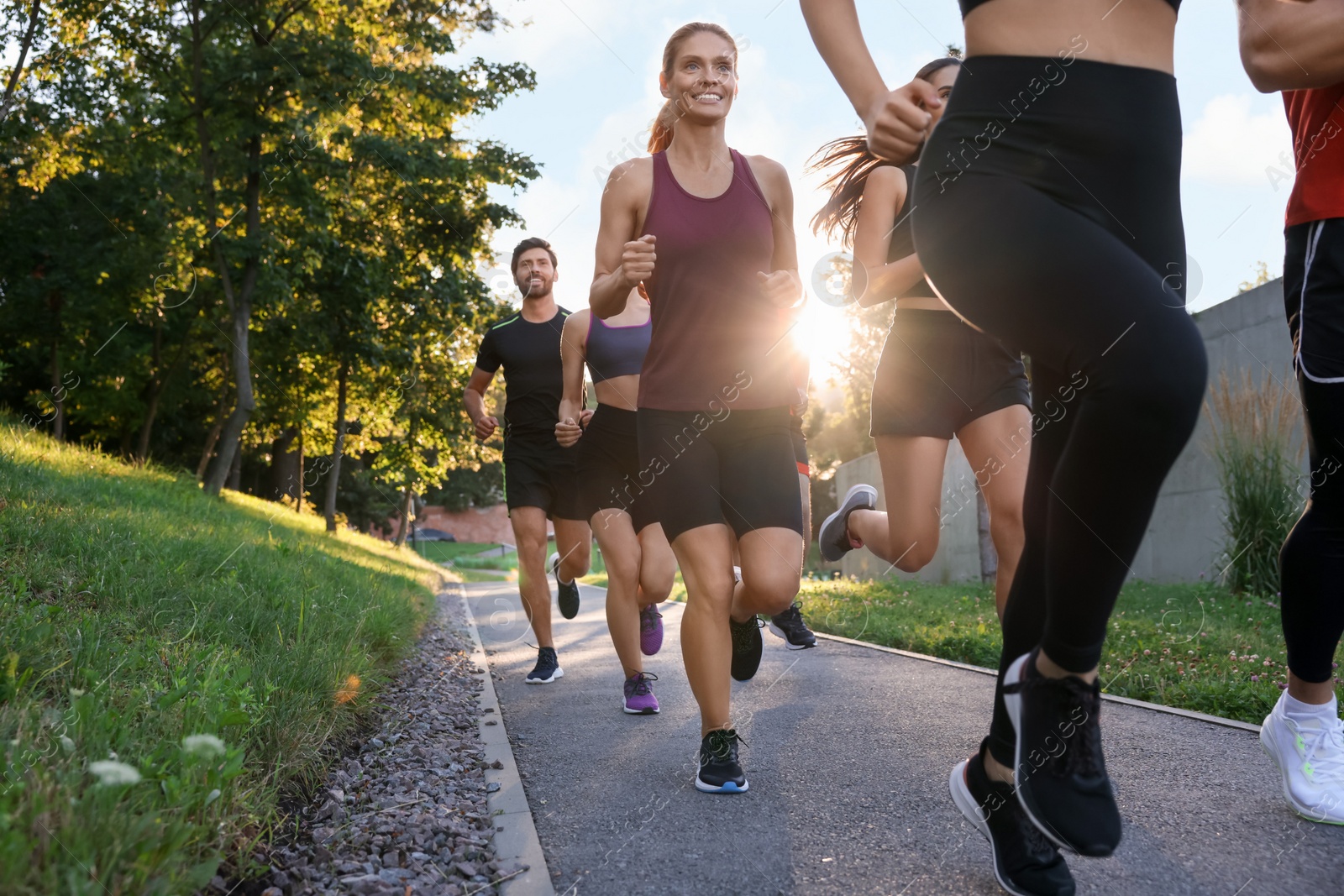 Photo of Group of people running outdoors on sunny day