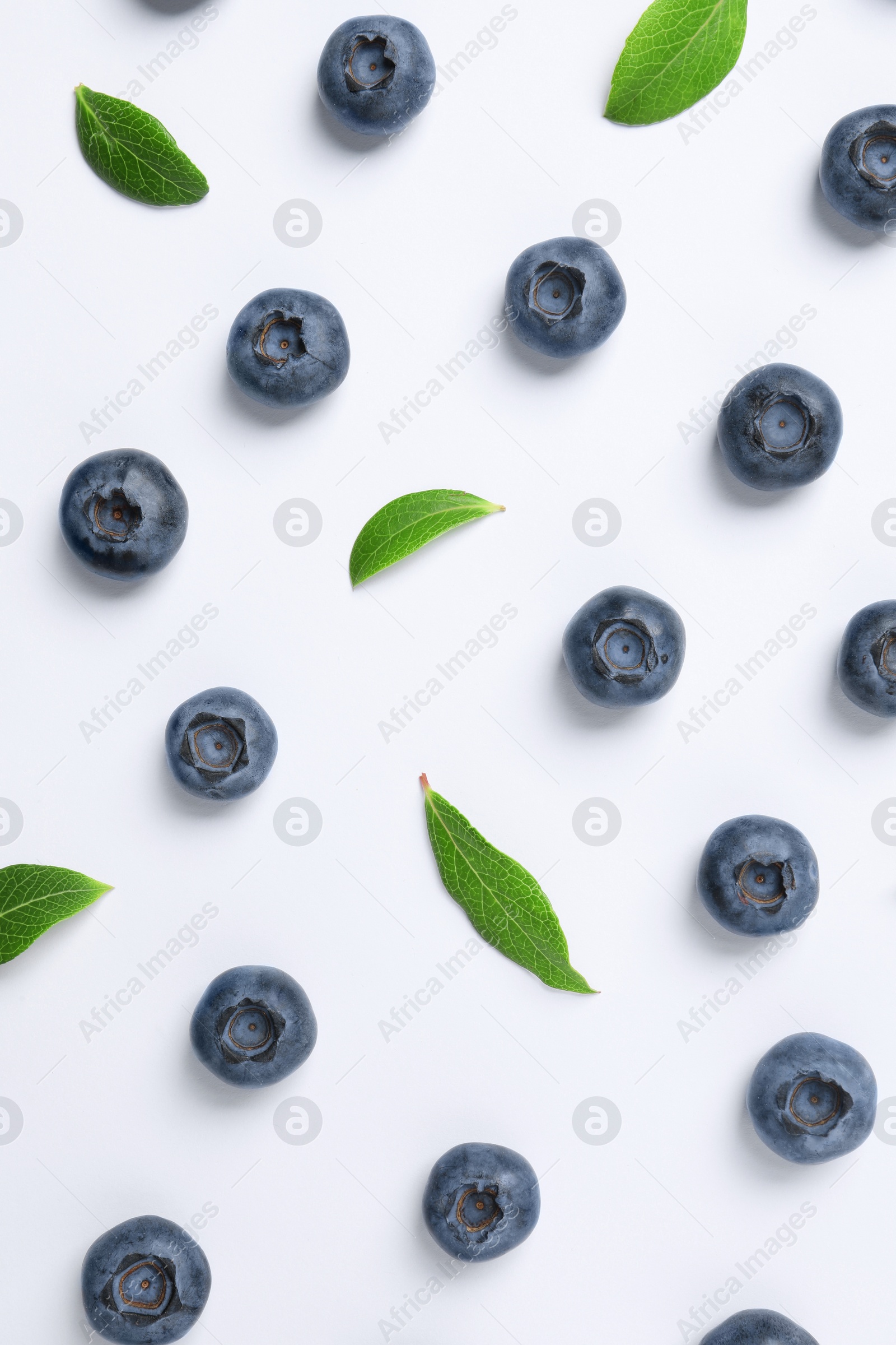 Photo of Tasty fresh blueberries with green leaves on white background, flat lay