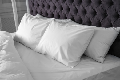 Photo of Bed with soft fluffy pillows at home