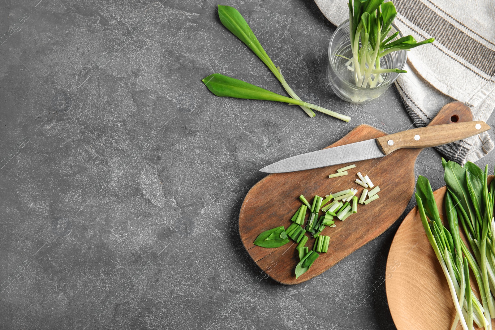 Photo of Flat lay composition wild garlic or ramson on grey table. Space for text