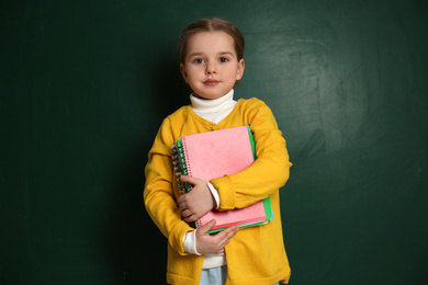 Photo of Cute little child near chalkboard. First time at school