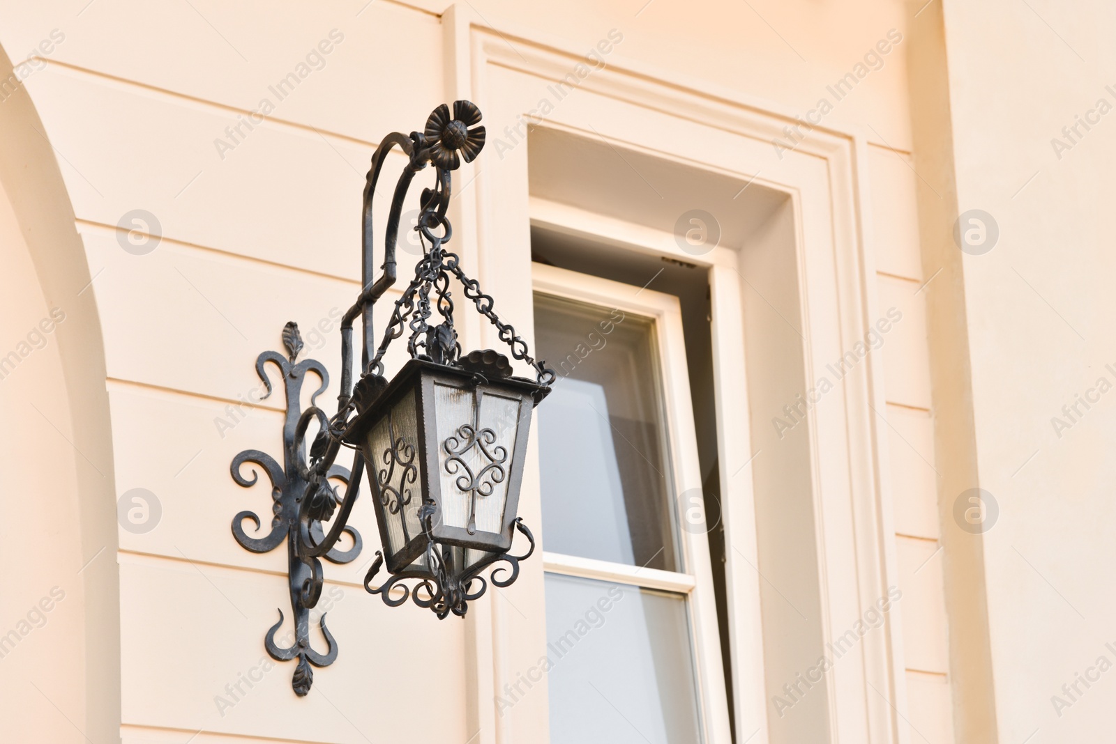 Photo of Beautiful vintage street lamp hanging on wall of building