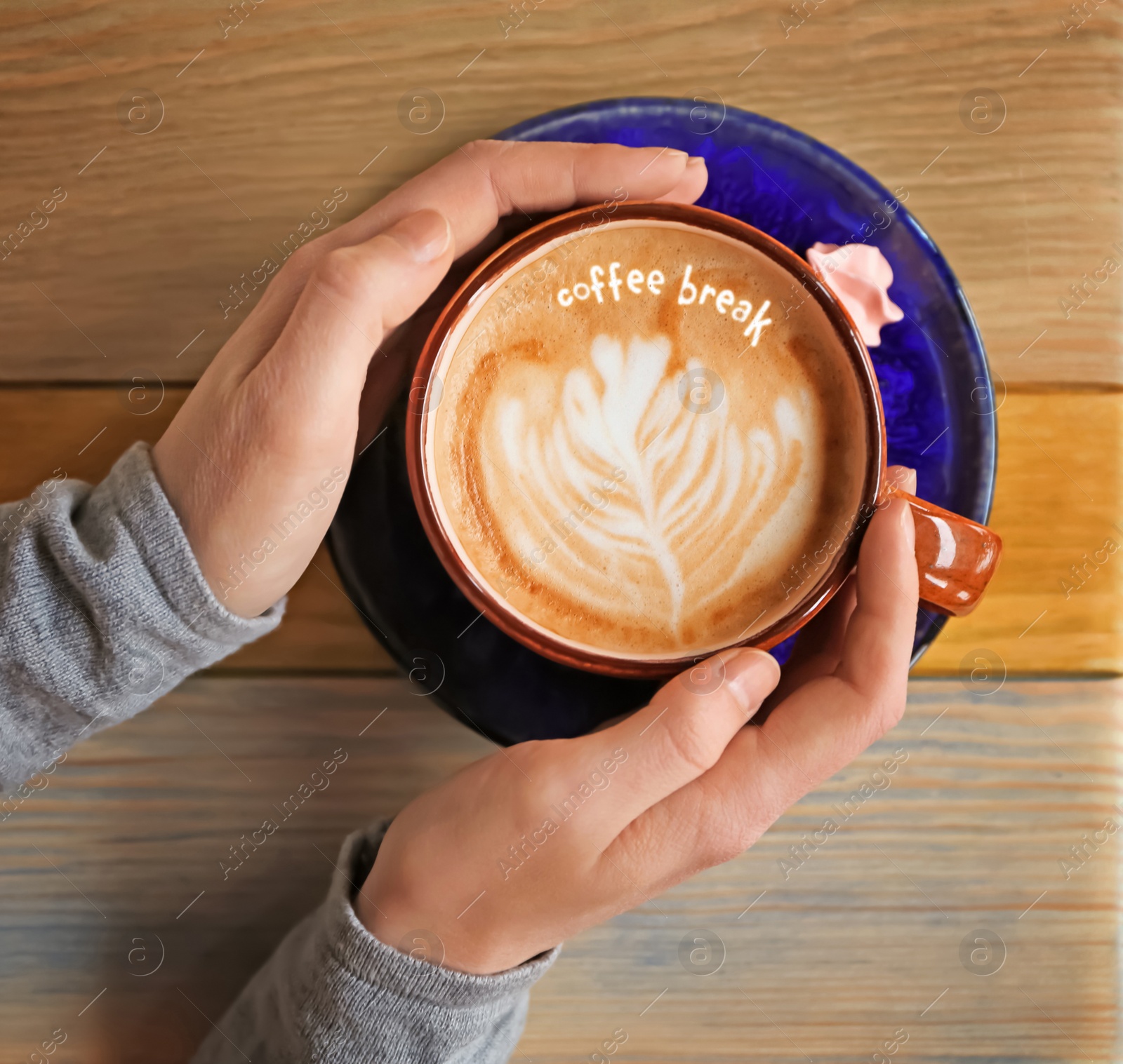 Image of Coffee Break. Woman with cup of cappuccino at wooden table, top view