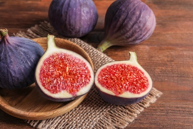 Photo of Plate with fresh ripe figs on wooden background. Tropical fruit