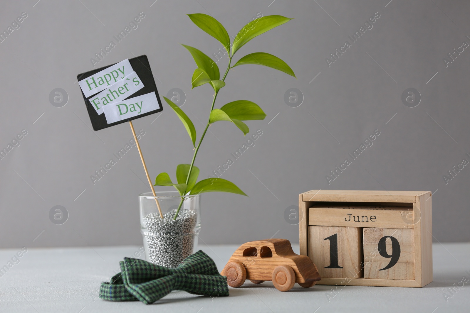 Photo of Composition with calendar and bow tie on table. Father's day celebration