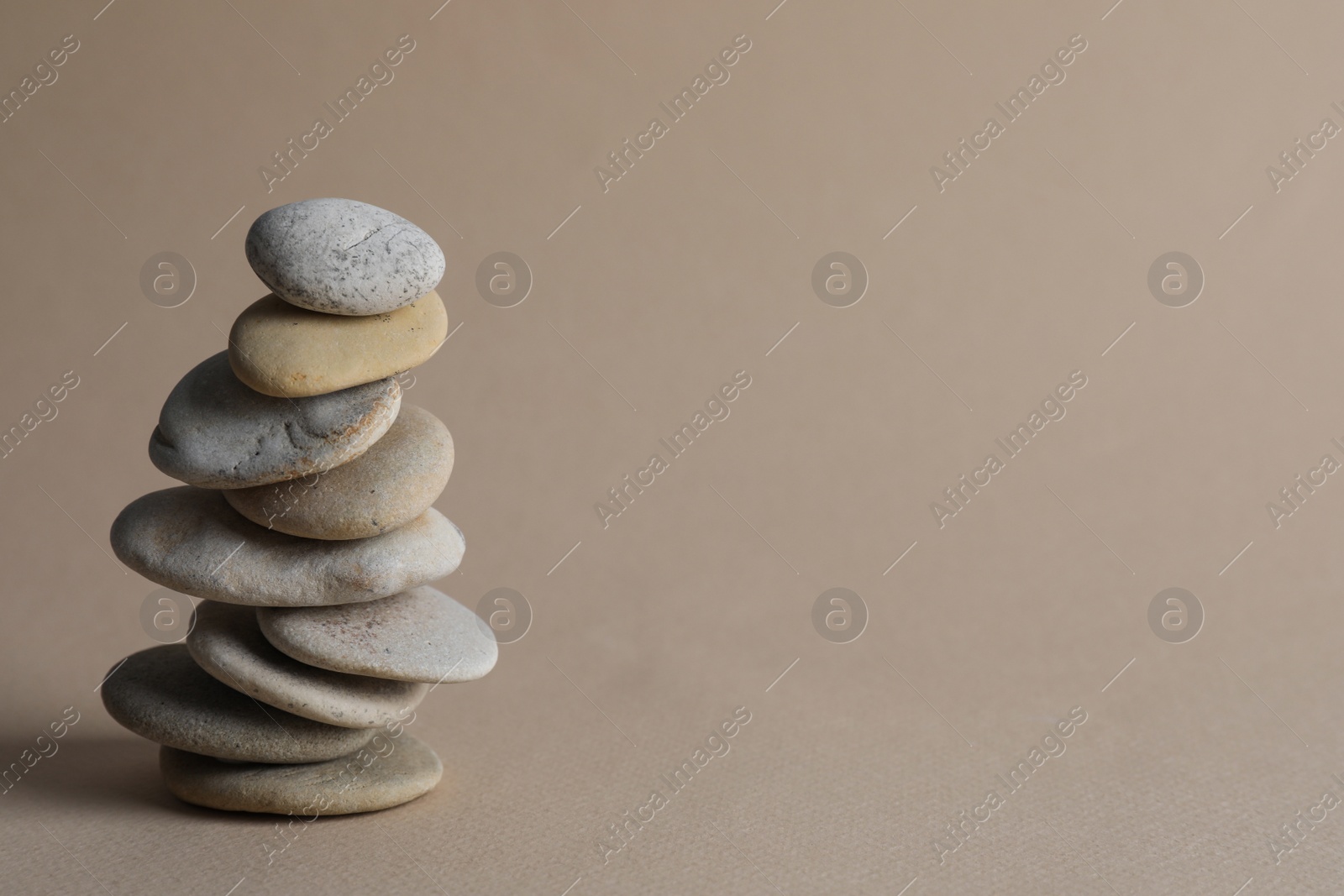 Photo of Stack of stones on beige background, space for text. Harmony and balance concept