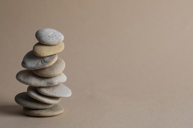 Stack of stones on beige background, space for text. Harmony and balance concept