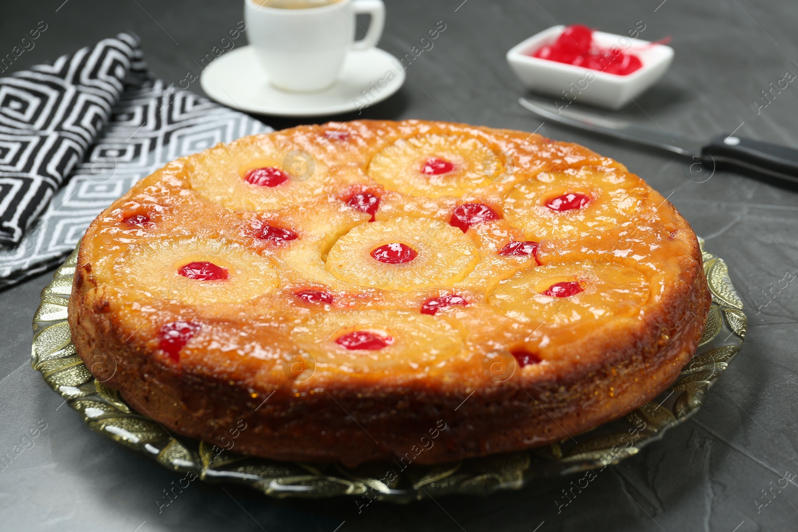 Photo of Plate with tasty pineapple cake on grey textured table, closeup