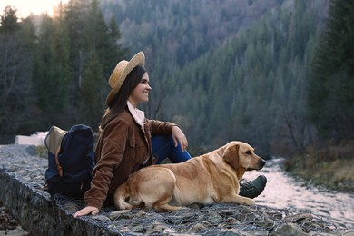 Happy woman and adorable dog in mountains. Traveling with pet
