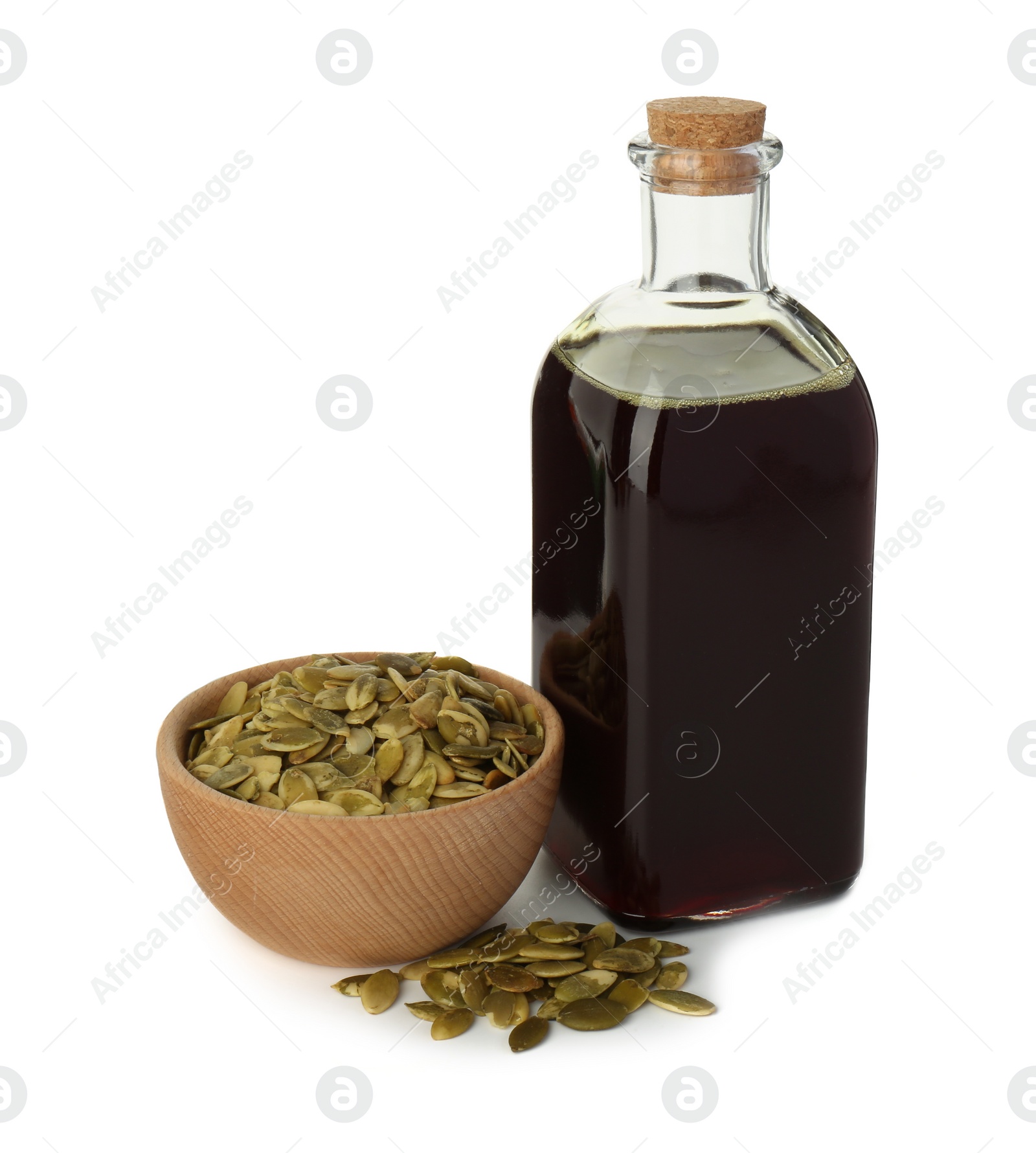 Photo of Vegetable fats. Pumpkin seed oil in glass bottle and seeds isolated on white