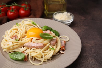 Photo of Delicious pasta Carbonara with egg yolk on grey table, closeup