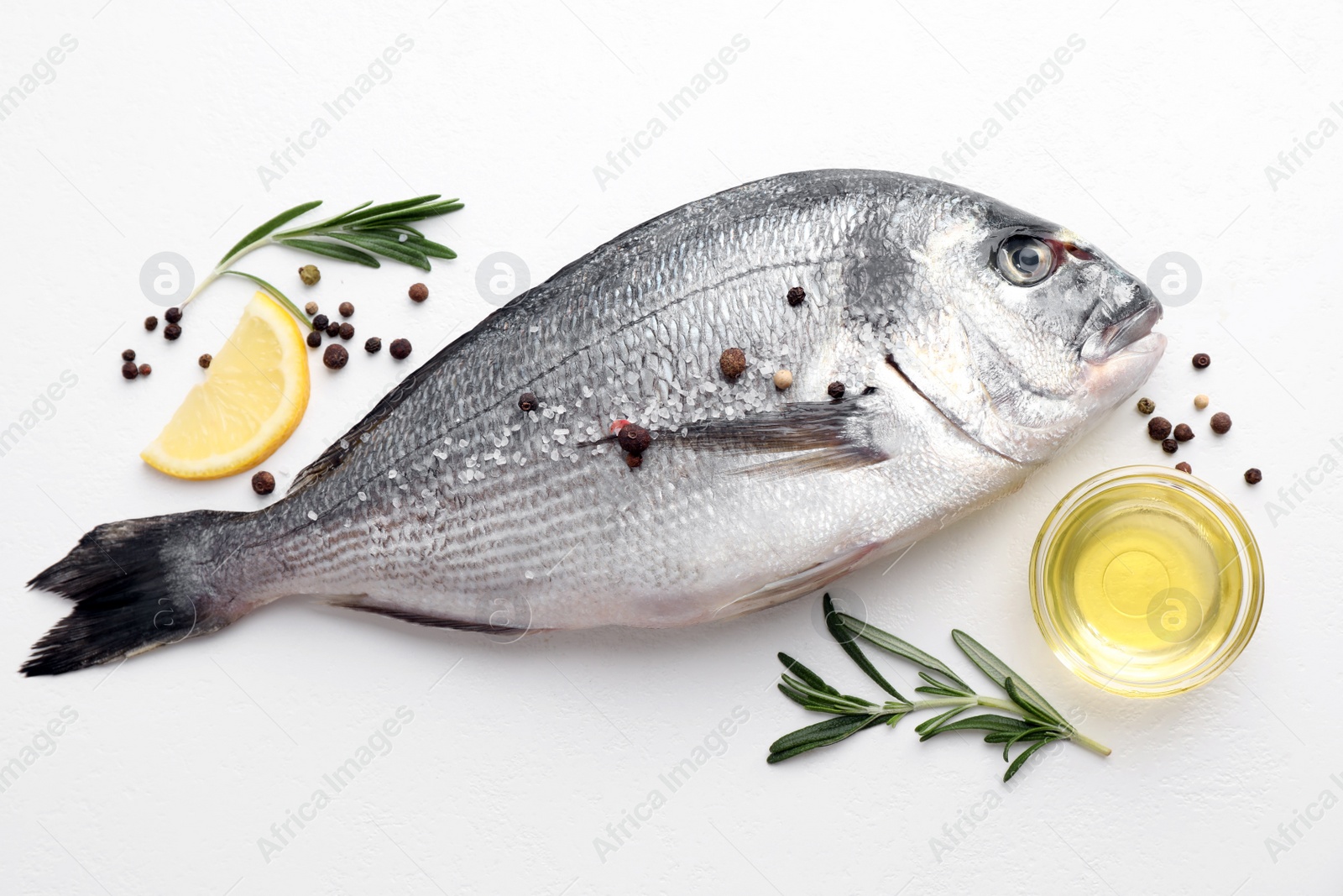 Photo of Flat lay composition with fresh raw dorado fish and ingredients on white table