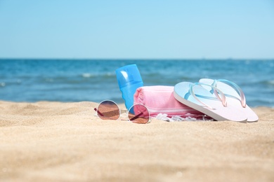 Photo of Set of different beach objects on sand near sea. Space for text