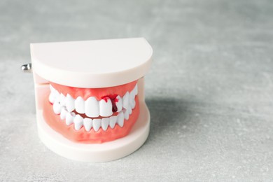 Photo of Model of jaw with blood on light grey table, space for text. Gum inflammation