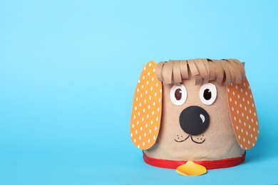 Photo of Toy dog made of toilet paper roll on light blue background. Space for text
