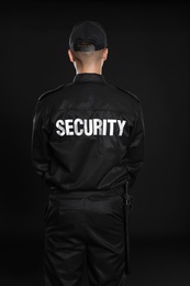 Male security guard in uniform on dark background