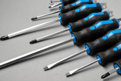 Photo of Set of screwdrivers on grey background, closeup