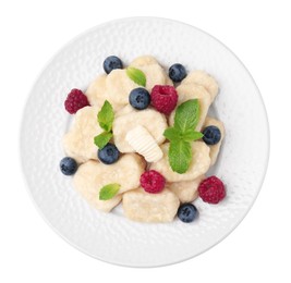 Photo of Plate of tasty lazy dumplings with berries, mint leaves and butter isolated on white, top view